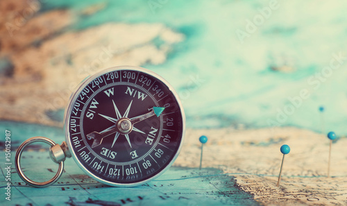 Compass on top of map with pins
